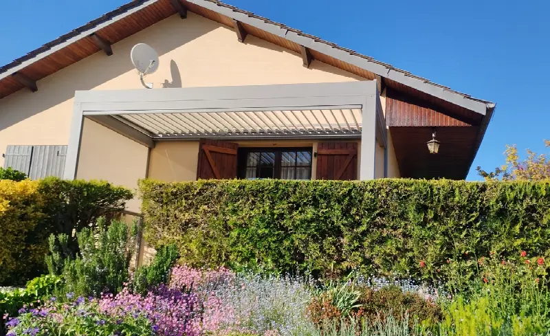 Pergola bioclimatique autoportée dans un jardin