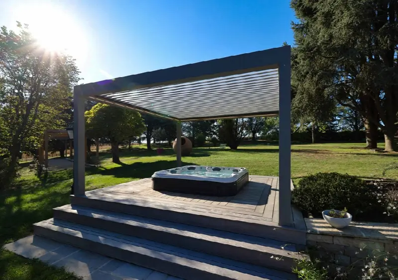 Pergola autoportée au-dessus d'un spa sur une terrasse en bois, dans un grand jardin