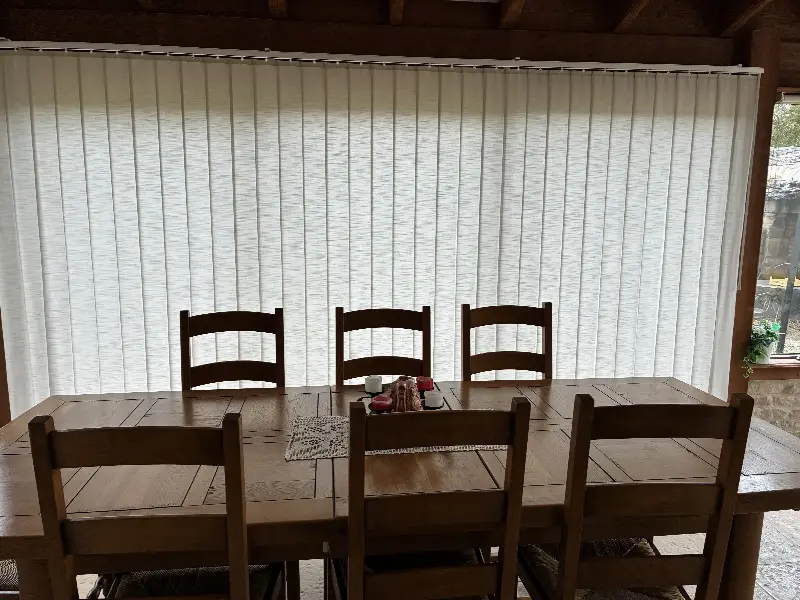 Stores à bandes verticales fermés derrière la table d'une véranda